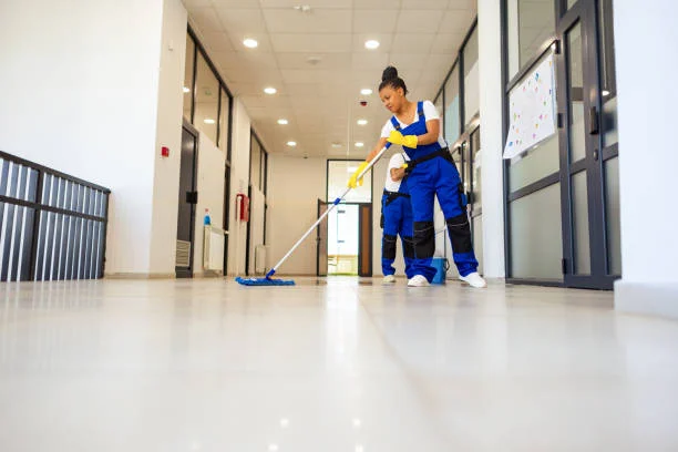 Professional janitorial worker mopping a high-traffic office corridor to prevent cross-contamination in a Bay Area facility.