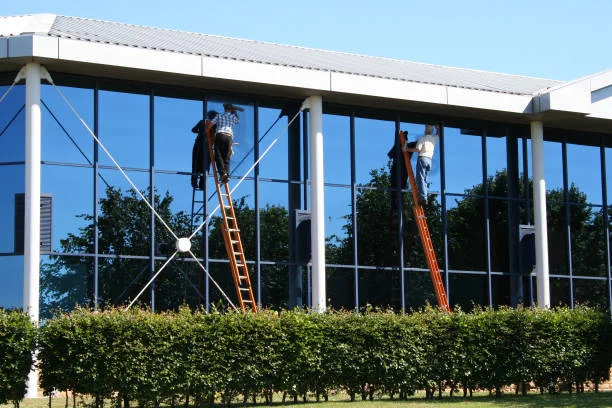 Professional commercial window cleaning team on scaffolding servicing a high-rise office building in the Bay Area.