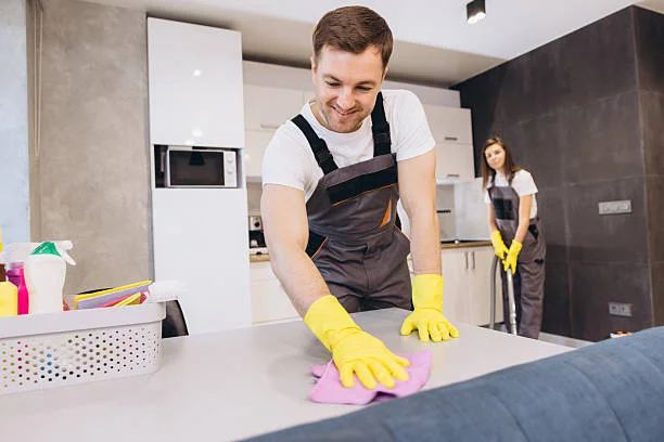 Professional day porter cleaning a commercial office breakroom counter in the Bay Area.
