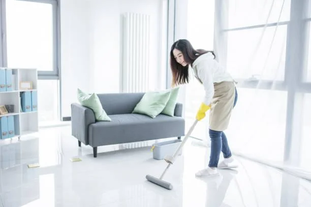 Professional cleaner mopping a modern office lounge area in a Bay Area commercial facility.